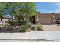 Charming single-story home featuring a well-manicured front yard with lush landscaping and a welcoming two-car garage at 11872 W Duane Ln, Peoria, AZ 85383