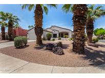Charming single-story home boasts mature palm trees, desert landscaping, and a welcoming covered front porch at 14124 W Bent Tree S Cir, Litchfield Park, AZ 85340