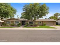 Charming single-story home with mature landscaping, a two-car garage and a basketball hoop at 143 E Winter Dr, Phoenix, AZ 85020