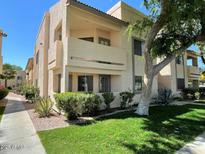 Charming condo building with a well-maintained lawn, mature trees, and desert landscaping at 145 N 74Th St # 125, Mesa, AZ 85207