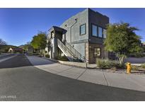 Contemporary two-story home features a stucco exterior, stone accents, and a staircase leading to an upper-level entrance at 16525 E Avenue Of The Fountain -- # 113, Fountain Hills, AZ 85268