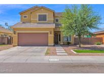 Charming two-story home with a brown two-car garage and a meticulously landscaped front yard at 2519 W Burgess Ln, Phoenix, AZ 85041