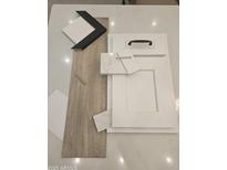 Selection of interior design finishes including flooring, cabinets, backsplash, and countertop samples at 2559 E Virginia Cir, Mesa, AZ 85213