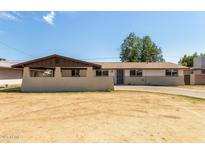 Charming single-story home featuring a neutral color palette and a spacious front yard at 3719 W Griswold Rd, Phoenix, AZ 85051