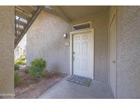 Inviting front door with welcome mat and fresh landscaping, providing a warm entrance to the home at 3830 E Lakewood Pkwy # 1057, Phoenix, AZ 85048
