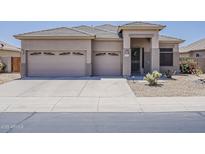 Charming single-story home featuring a well-manicured yard, neutral paint, and a three-car garage at 43319 W Oakland Ct, Maricopa, AZ 85138