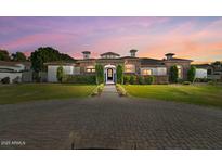 Elegant single-story home with manicured lawn and circular brick driveway at 5827 S Marin Ct, Gilbert, AZ 85298