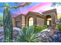 Inviting single-story home featuring desert landscaping, a two-car garage, and a charming walkway to the front door at 7094 E Palo Brea Dr, Gold Canyon, AZ 85118