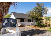 Quaint home with a white picket fence and a unique horse-themed mural on the side at 8132 E 3Rd Ave, Mesa, AZ 85208