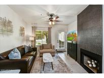 Inviting living room features sleek tile flooring, and a cozy fireplace with eye-catching mosaic tile surround at 9451 E Becker Ln # 1051, Scottsdale, AZ 85260