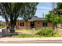 Charming single-story home featuring a tidy front yard with a white fence and mature landscaping at 1134 W 2Nd St, Mesa, AZ 85201