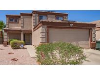 Tan two-story home with a two-car garage and well-kept landscaping at 12422 W Rosewood Dr, El Mirage, AZ 85335
