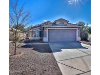 Charming single-story home with a well-manicured front yard, tile roof, and a two-car garage at 13241 W Desert Ln, Surprise, AZ 85374