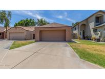 Exterior view of the home featuring a large two-car garage and a well-manicured lawn at 1836 N Stapley Dr # 191, Mesa, AZ 85203