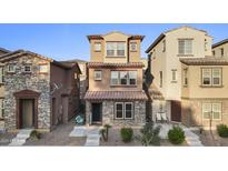 Charming two-story home featuring stone accents, a tiled roof, and a well-maintained front yard at 2111 N 77Th Gln, Phoenix, AZ 85035