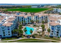 Stunning aerial view of the community featuring a pool, palm trees, and well-manicured landscaping at 2511 W Queen Creek Rd # 116, Chandler, AZ 85248