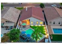 Aerial view of a backyard with a pool, patio furniture, and a well-maintained lawn with privacy at 3224 E Desert Cove Ave, Phoenix, AZ 85028