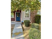 Charming home featuring a blue front door, stone accents, manicured bushes, and sidewalk leading to entrance at 3756 E Kerry Ln, Phoenix, AZ 85050
