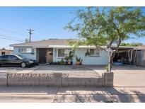 Charming single-story home with blue exterior, decorative rock yard and large covered carport at 8724 N 28Th Ave, Phoenix, AZ 85051