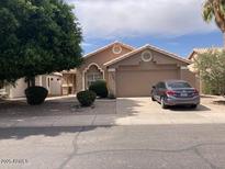Tan single-story home with desert landscaping, large shade tree and a two-car garage at 914 W Morelos St, Chandler, AZ 85225