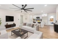 Bright living room with modern fan, white sofa, and open access to a renovated kitchen at 1368 W 14Th St, Tempe, AZ 85281