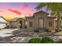 Inviting single-story home featuring desert landscaping and a tile roof at sunset at 18391 W Stinson Dr, Surprise, AZ 85374