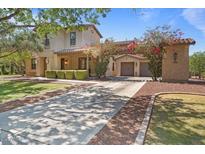 Charming home showcasing a well-manicured lawn, mature trees, and a welcoming entrance with a two-car garage at 20638 W Main St, Buckeye, AZ 85396