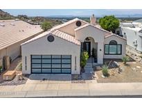Charming stucco home with a modern garage door, desert landscaping, and a beautiful tile roof at 21 W Cochise Dr, Phoenix, AZ 85021