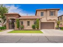 Charming stucco two-story home featuring a gated courtyard, tile roof and neatly manicured landscaping at 2308 E Aster Dr, Chandler, AZ 85286