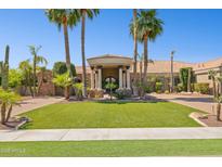Stunning home featuring an elegant portico entrance, lush landscaping, and majestic palm trees on a sunny day at 3731 E Halifax Cir, Mesa, AZ 85205