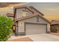 Charming home featuring a two-car garage, tiled roof, neutral stucco, and well-manicured landscaping at 41158 W Cahill Dr, Maricopa, AZ 85138