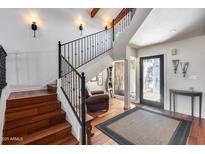Inviting foyer featuring wood floors, a staircase with iron railings, and a view to the home's entrance at 4242 N 44Th St, Phoenix, AZ 85018