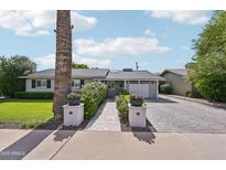 Charming single-story home featuring a well-manicured lawn and a brick driveway leading to an attached garage at 4320 N 35Th St, Phoenix, AZ 85018