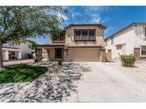 Two-story home with a two-car garage, desert landscaping, and tan exterior paint at 10440 E Osage Ave, Mesa, AZ 85212
