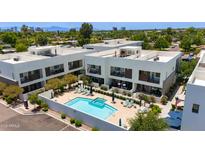 Aerial view showcases community pool, outdoor seating, landscaping, and modern building architecture at 1111 E Missouri Ave # 9, Phoenix, AZ 85014