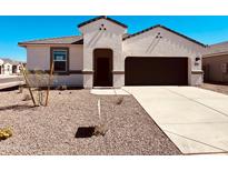 Charming single-Gathering home with a dark-colored garage door, neutral-colored exterior, and low-maintenance landscaping at 11858 E Cliffrose Ln, Florence, AZ 85132