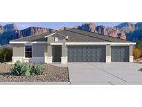 Charming single-story home featuring a three-car garage and low maintenance desert landscaping against a mountain backdrop at 12232 E Agave Ln, Florence, AZ 85132