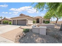 Charming home boasts a three-car garage, desert landscaping, and a covered entryway, blending curb appeal with Southwestern charm at 15989 W Indianola Ave, Goodyear, AZ 85395