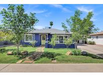 Charming blue home with a well-manicured front yard and inviting walkway at 1639 W Indianola Ave, Phoenix, AZ 85015