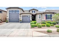 Charming single-story home with a well-manicured front yard, complemented by a gray exterior and three-car garage at 17815 W Straight Arrow Ln, Surprise, AZ 85387