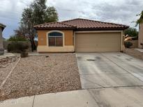Single-story home featuring neutral stucco, a tile roof, gravel landscaping, and a two-car garage at 20761 N Herbert Ave, Maricopa, AZ 85138