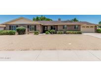Charming brick home featuring a well-manicured gravel yard and a convenient two-car garage at 4402 W El Caminito Dr, Glendale, AZ 85302