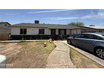 Charming single-story home with a quaint walkway and driveway parking at 4823 W Palm Ln, Phoenix, AZ 85035