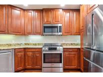 Well-lit kitchen features stainless steel appliances, granite countertops and wooden cabinetry at 5450 E Deer Valley Dr # 1214, Phoenix, AZ 85054