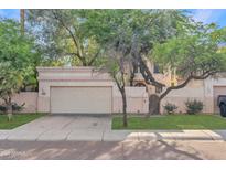 Charming home exterior featuring a two-car garage and beautiful mature trees in a well-maintained front yard at 6002 N 5Th Pl, Phoenix, AZ 85012