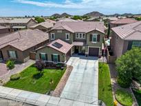 Two-story home with a well-manicured lawn, three-car garage, and solar panels in a quiet residential neighborhood at 761 W Desert Hollow Dr, San Tan Valley, AZ 85143