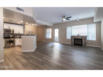 Open-concept living room featuring a fireplace, modern fan, and seamless flow to the updated kitchen at 16 W Encanto Blvd # 110, Phoenix, AZ 85003