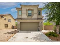 Two-story home with a light beige exterior, a two-car garage, and a well-maintained front yard with green plants at 40345 W Molly Ln, Maricopa, AZ 85138