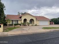 Charming single-story home featuring an arched entryway, desert landscaping, and a spacious two-car garage at 4801 E Sheena Dr, Scottsdale, AZ 85254