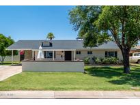 Charming single-story home featuring a well-manicured lawn, covered porch and stylish architectural details at 6302 N 13Th Pl, Phoenix, AZ 85014